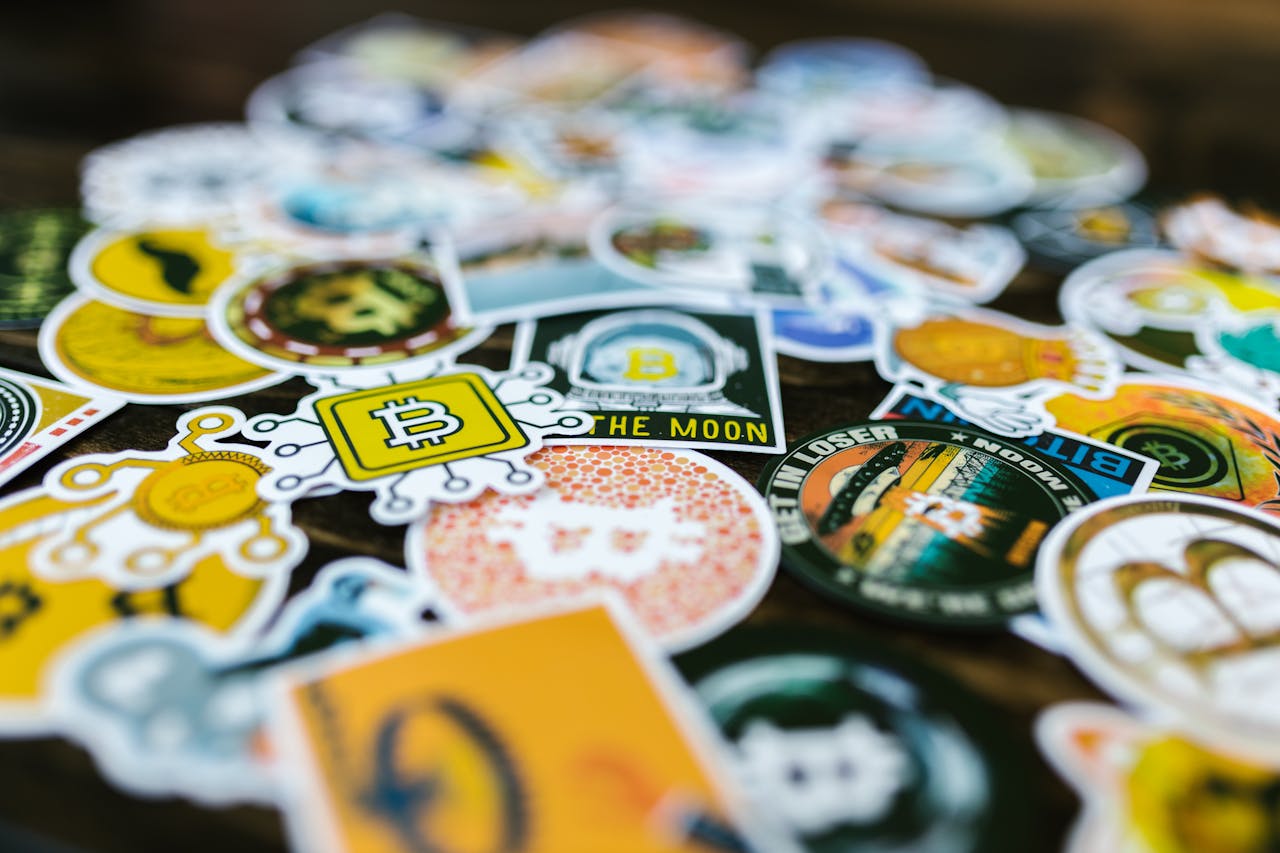 Vibrant Bitcoin and cryptocurrency-themed stickers scattered on a surface.